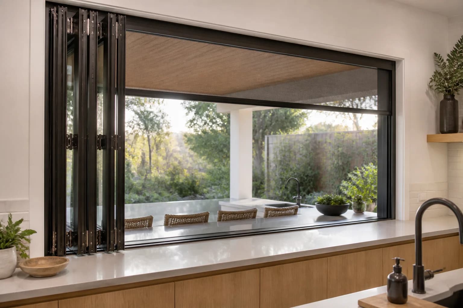 Four-panel folding kitchen pass-through window above a continuous counter