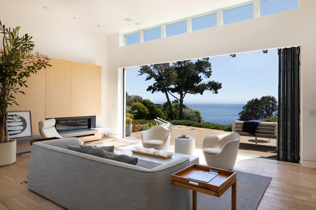 Living room with folding glass doors open to an ocean view